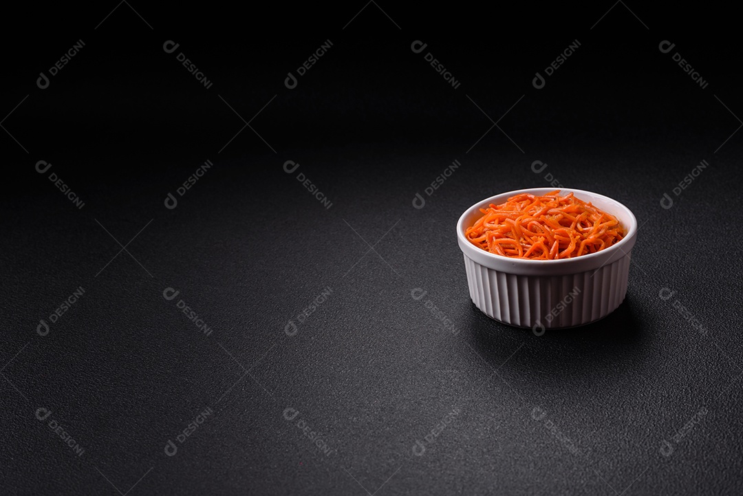 Saborosa cenoura coreana picante com especiarias e ervas em um fundo escuro de concreto. comida asiática