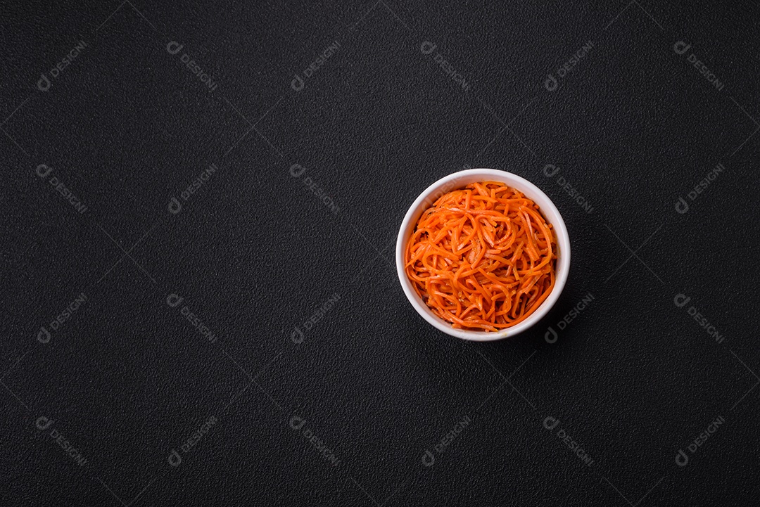 Saborosa cenoura coreana picante com especiarias e ervas em um fundo escuro de concreto. comida asiática