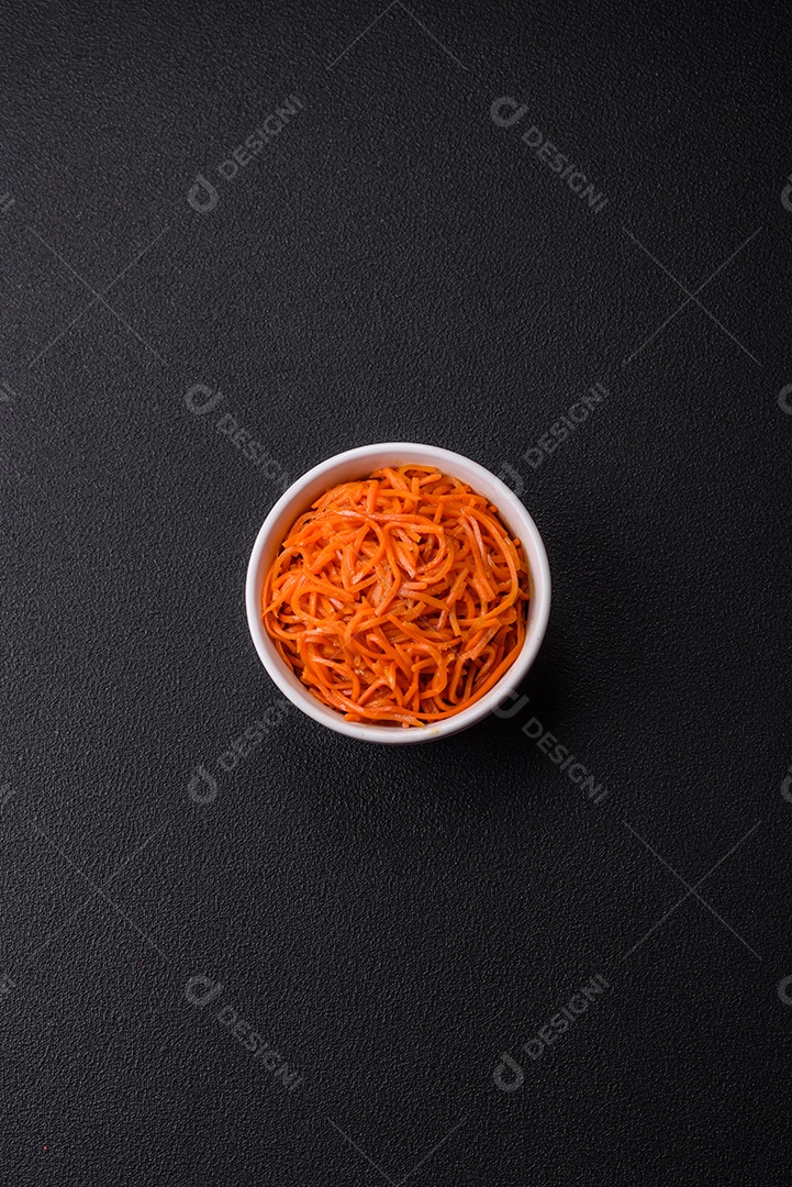 Saborosa cenoura coreana picante com especiarias e ervas em um fundo escuro de concreto. comida asiática