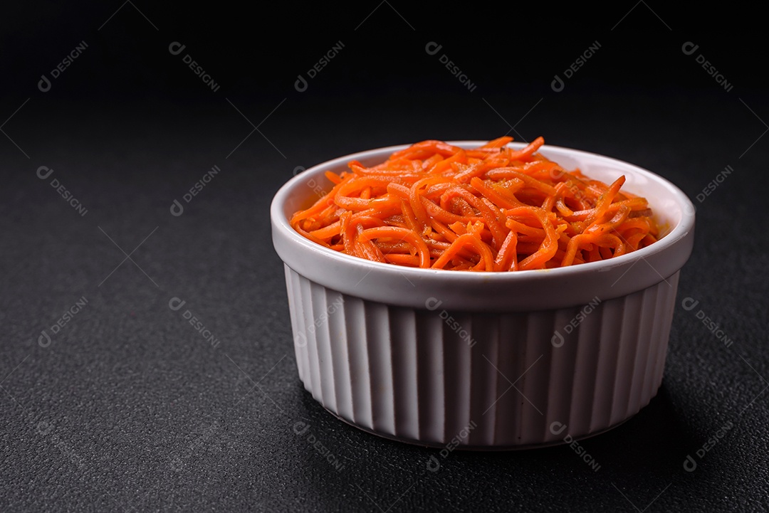 Saborosa cenoura coreana picante com especiarias e ervas em um fundo escuro de concreto. comida asiática