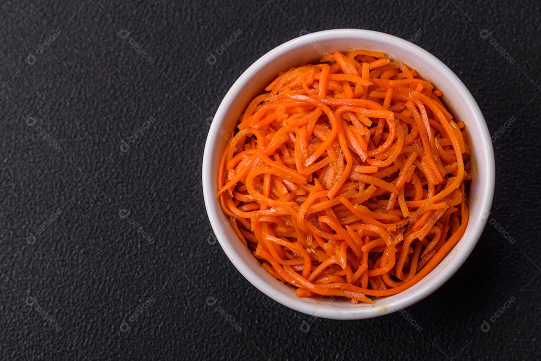 Saborosa cenoura coreana picante com especiarias e ervas em um fundo escuro de concreto. comida asiática