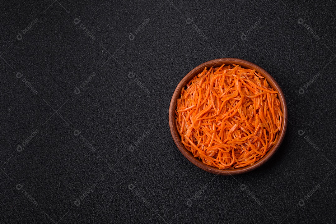 Saborosa cenoura coreana picante com especiarias e ervas em um fundo escuro de concreto. comida asiática