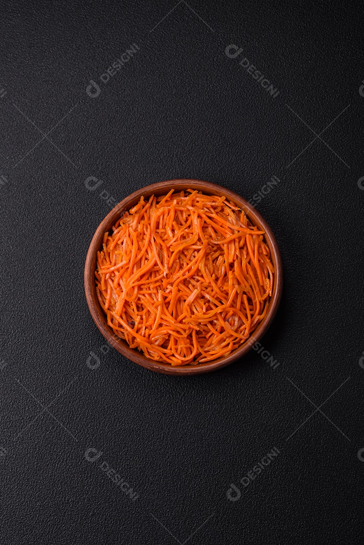 Saborosa cenoura coreana picante com especiarias e ervas em um fundo escuro de concreto. comida asiática