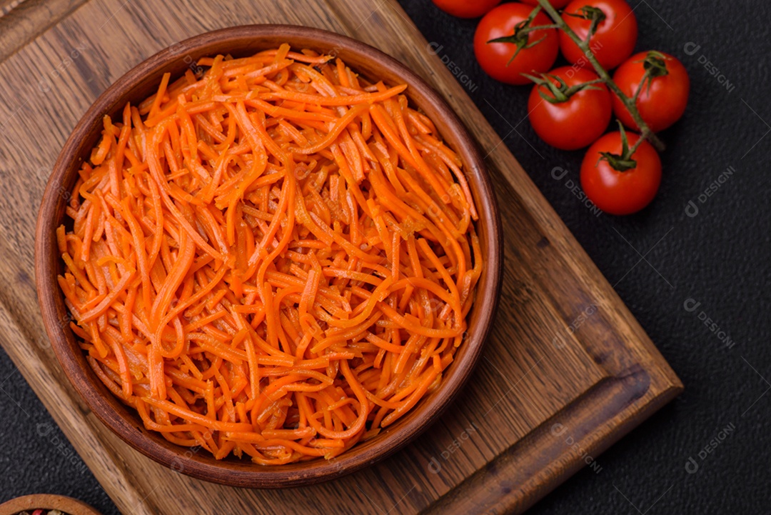 Saborosa cenoura coreana picante com especiarias e ervas em um fundo escuro de concreto. comida asiática