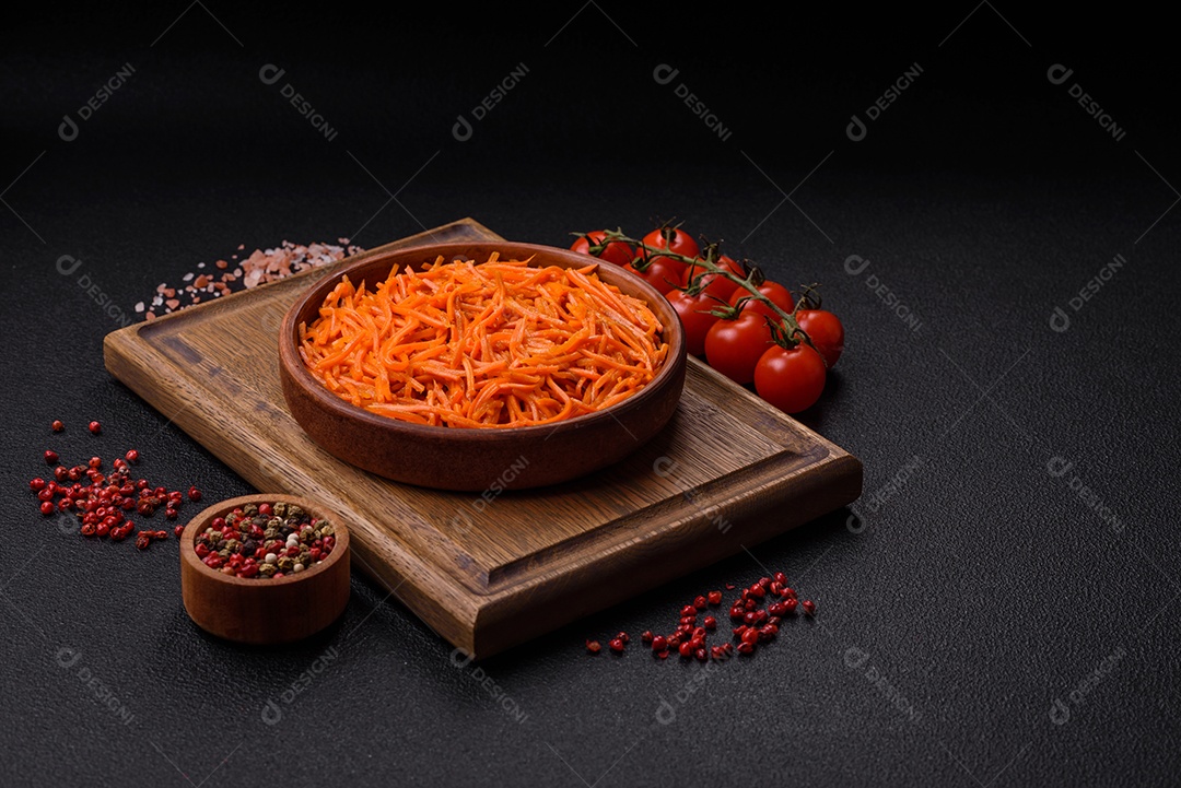 Saborosa cenoura coreana picante com especiarias e ervas em um fundo escuro de concreto. comida asiática