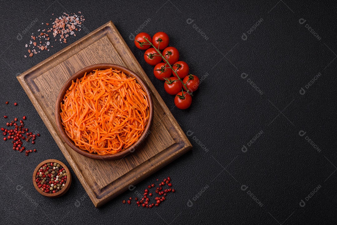 Saborosa cenoura coreana picante com especiarias e ervas em um fundo escuro de concreto. comida asiática