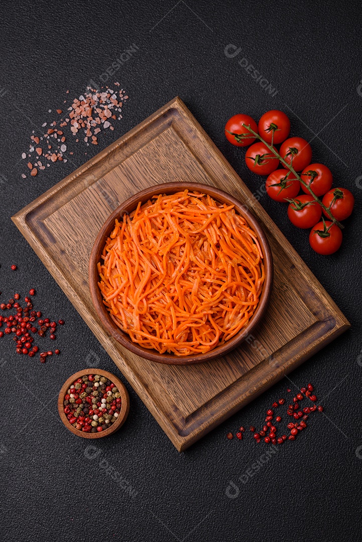 Saborosa cenoura coreana picante com especiarias e ervas em um fundo escuro de concreto. comida asiática