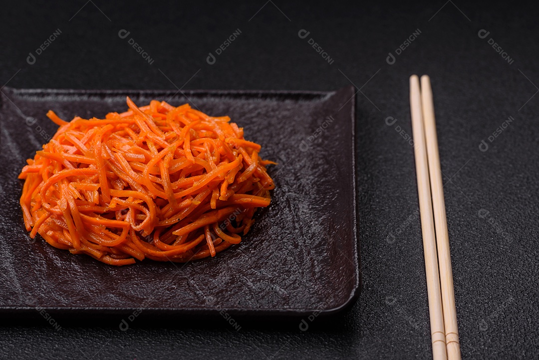 Saborosa cenoura coreana picante com especiarias e ervas em um fundo escuro de concreto. comida asiática