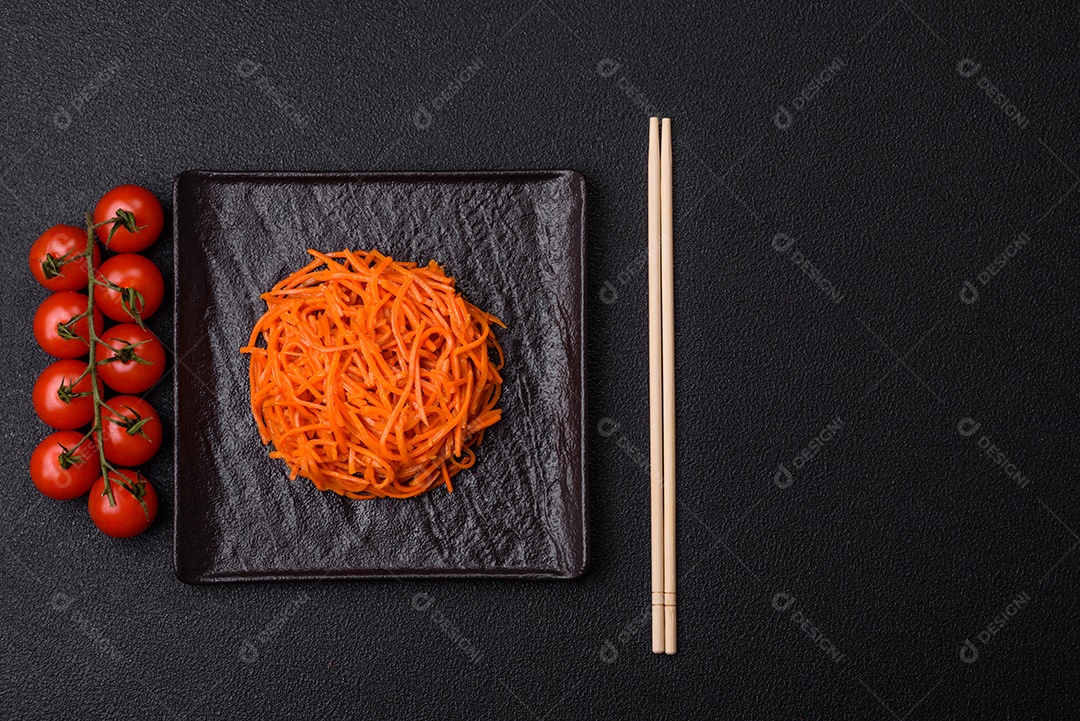 Saborosa cenoura coreana picante com especiarias e ervas em um fundo escuro de concreto. comida asiática