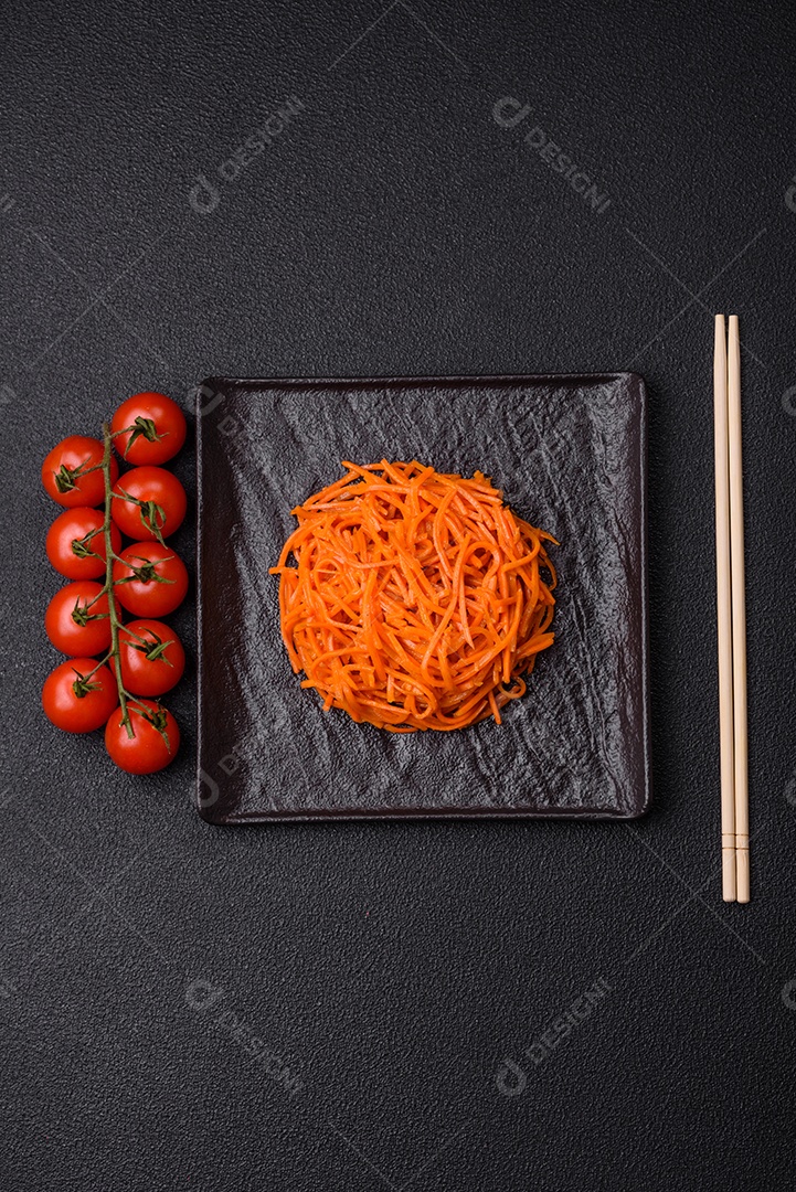 Saborosa cenoura coreana picante com especiarias e ervas em um fundo escuro de concreto. comida asiática