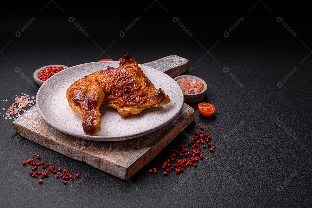 Deliciosa coxa ou quarto de frango grelhado com sal e especiarias em fundo escuro de concreto