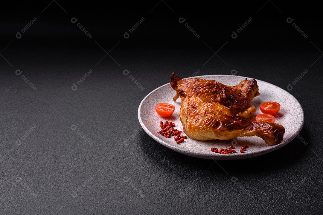 Deliciosa coxa ou quarto de frango grelhado com sal e especiarias em fundo escuro de concreto