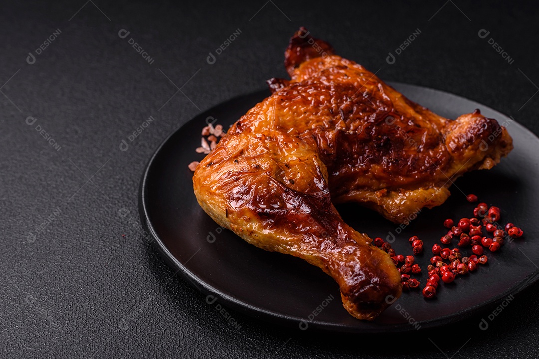 Deliciosa coxa ou quarto de frango grelhado com sal e especiarias em fundo escuro de concreto
