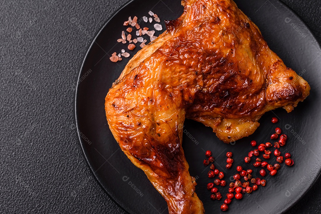 Deliciosa coxa ou quarto de frango grelhado com sal e especiarias em fundo escuro de concreto