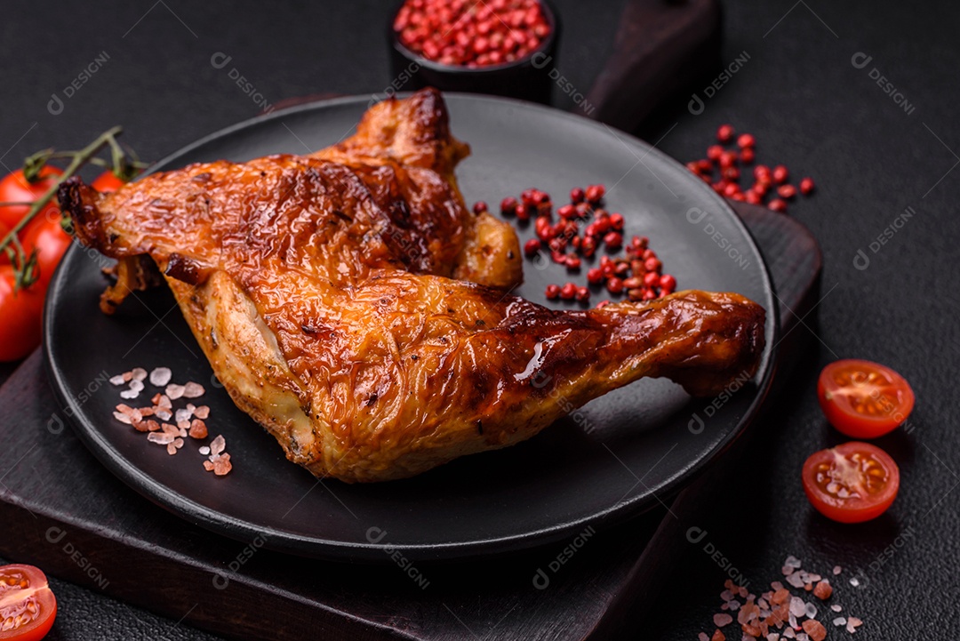 Deliciosa coxa ou quarto de frango grelhado com sal e especiarias em fundo escuro de concreto