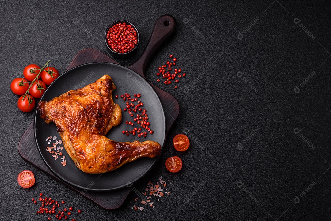 Deliciosa coxa ou quarto de frango grelhado com sal e especiarias em fundo escuro de concreto