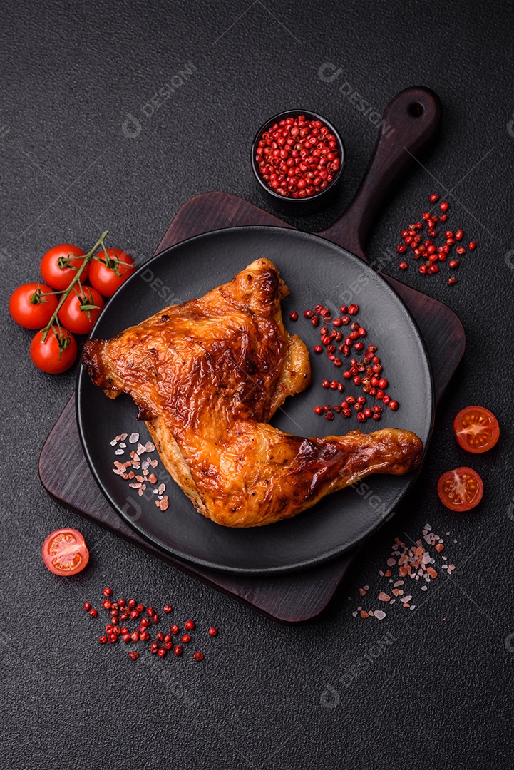 Deliciosa coxa ou quarto de frango grelhado com sal e especiarias em fundo escuro de concreto