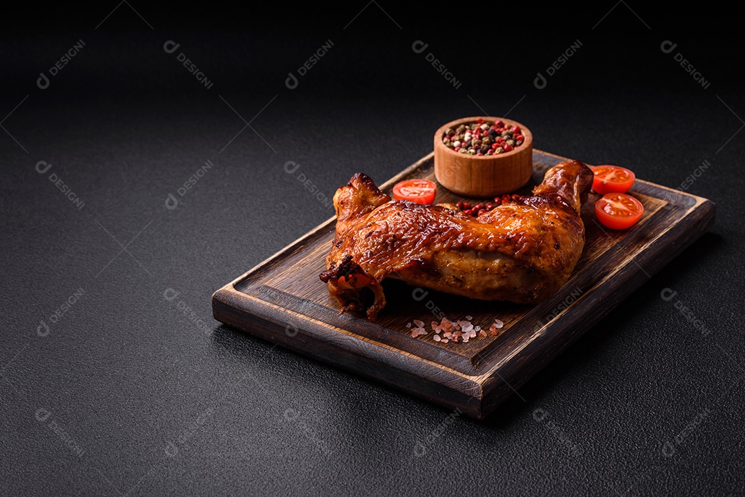Deliciosa coxa ou quarto de frango grelhado com sal e especiarias em fundo escuro de concreto