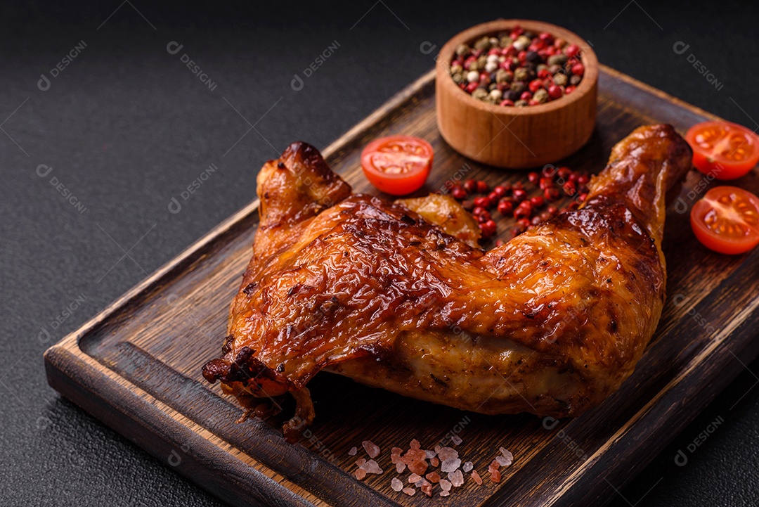 Deliciosa coxa ou quarto de frango grelhado com sal e especiarias em fundo escuro de concreto