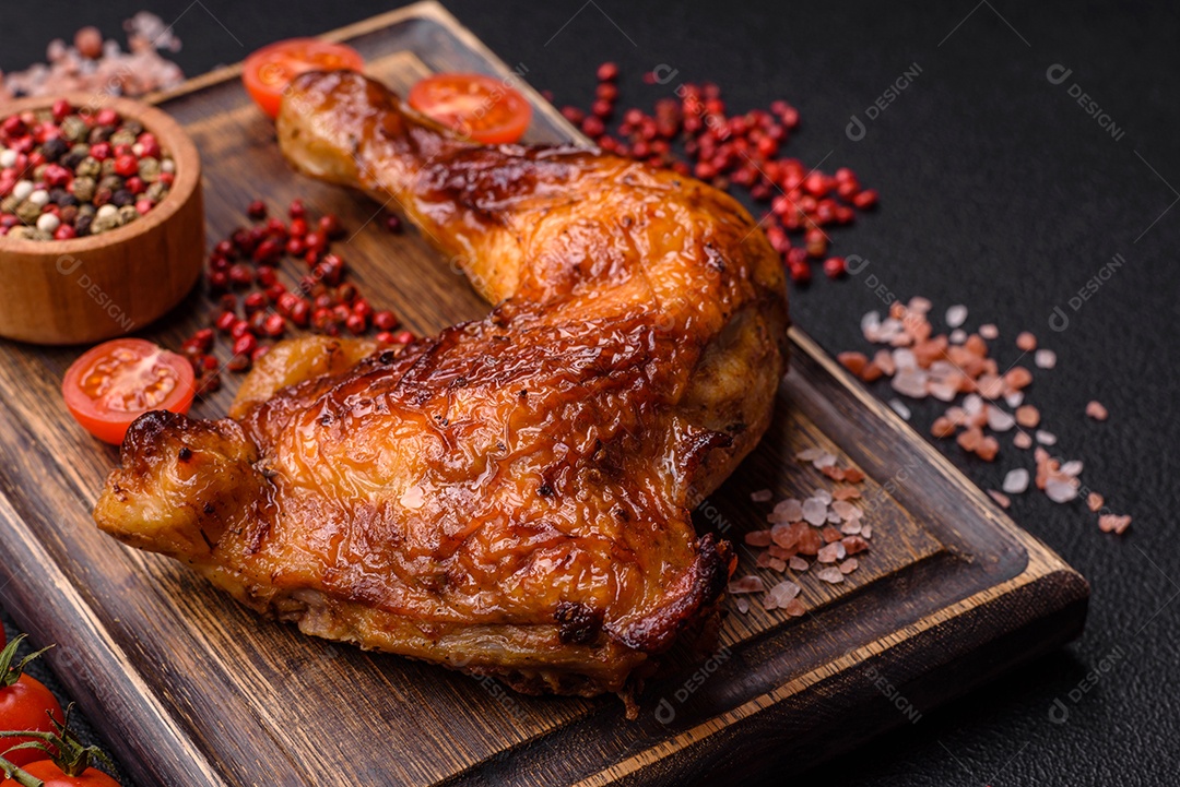 Deliciosa coxa ou quarto de frango grelhado com sal e especiarias em fundo escuro de concreto