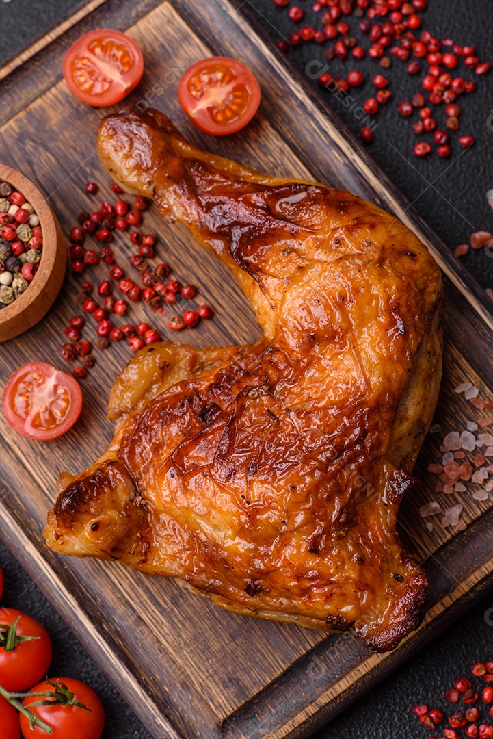 Deliciosa coxa ou quarto de frango grelhado com sal e especiarias em fundo escuro de concreto