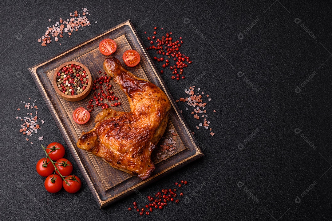 Deliciosa coxa ou quarto de frango grelhado com sal e especiarias em fundo escuro de concreto