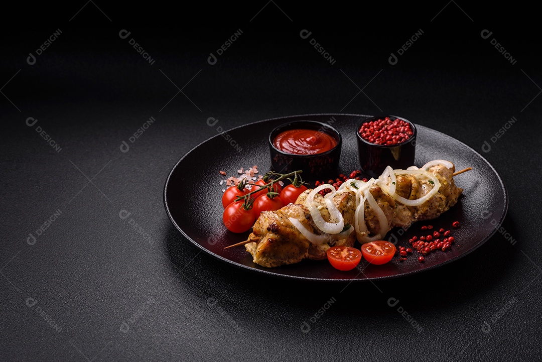 Delicioso kebab de carne de frango fresco com sal, especiarias e ervas sobre um fundo escuro de concreto