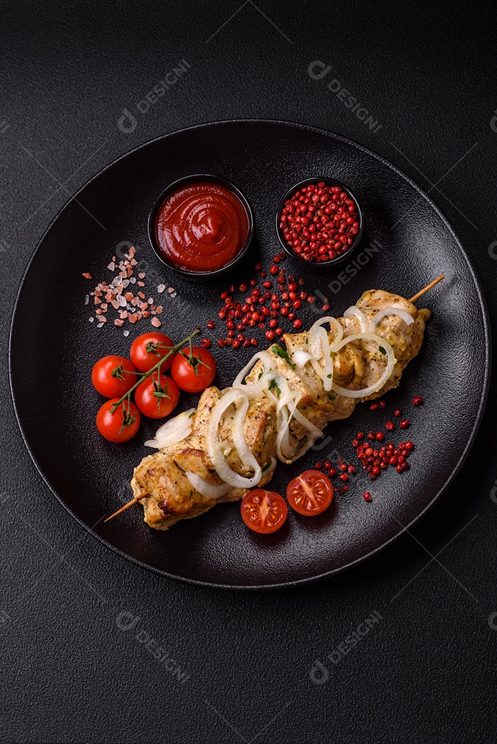 Delicioso kebab de carne de frango fresco com sal, especiarias e ervas sobre um fundo escuro de concreto