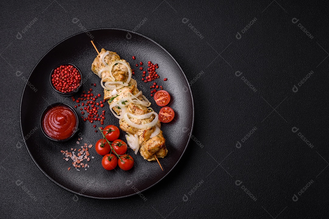 Delicioso kebab de carne de frango fresco com sal, especiarias e ervas sobre um fundo escuro de concreto