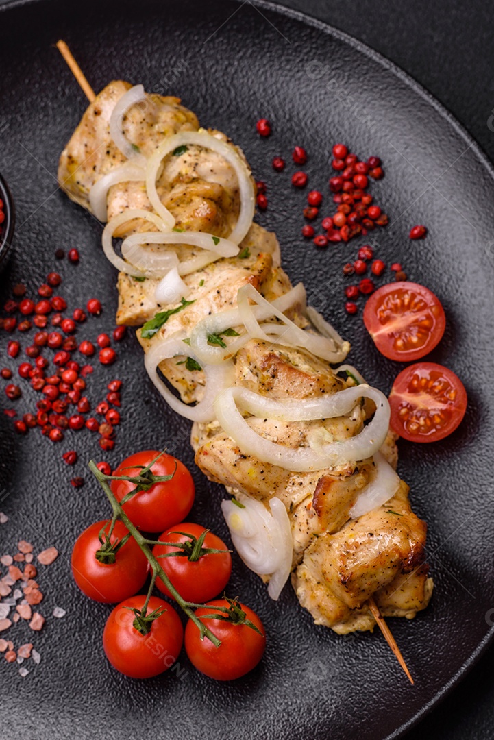 Delicioso kebab de carne de frango fresco com sal, especiarias e ervas sobre um fundo escuro de concreto