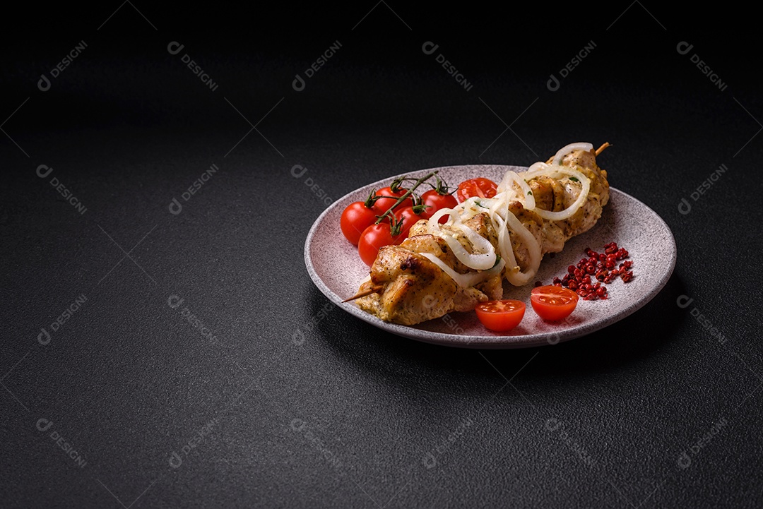 Delicioso kebab de carne de frango fresco com sal, especiarias e ervas sobre um fundo escuro de concreto