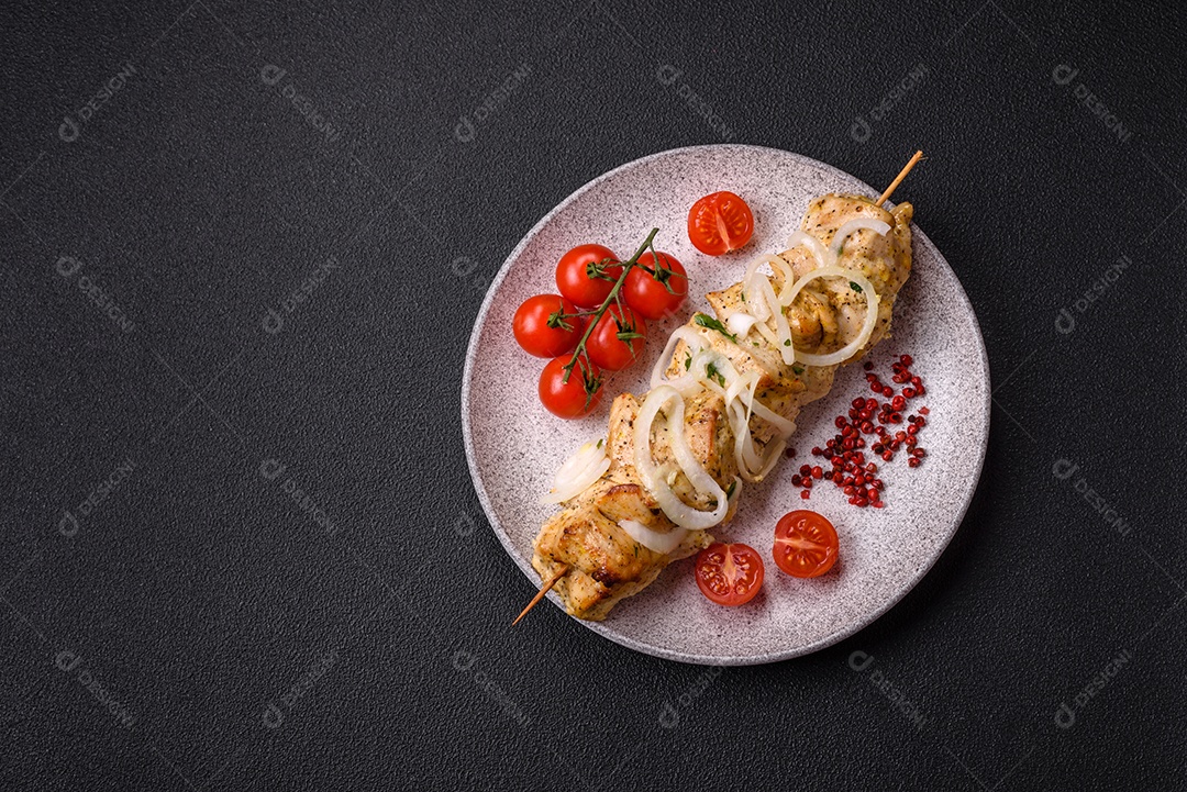 Delicioso kebab de carne de frango fresco com sal, especiarias e ervas sobre um fundo escuro de concreto