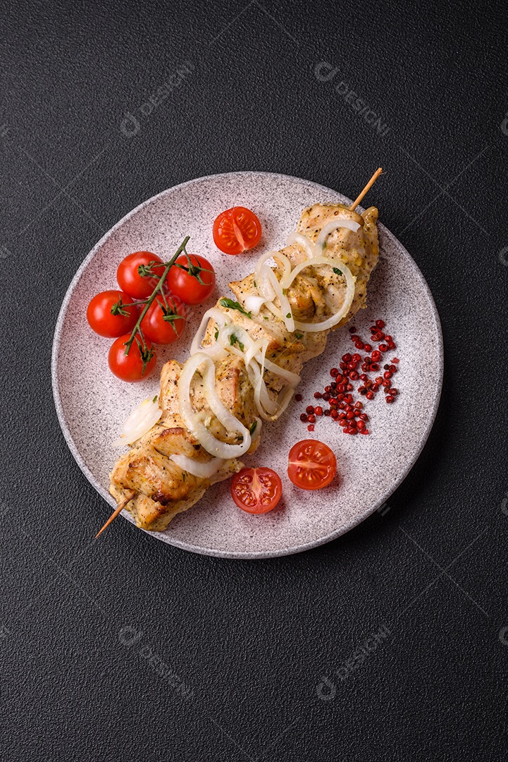 Delicioso kebab de carne de frango fresco com sal, especiarias e ervas sobre um fundo escuro de concreto