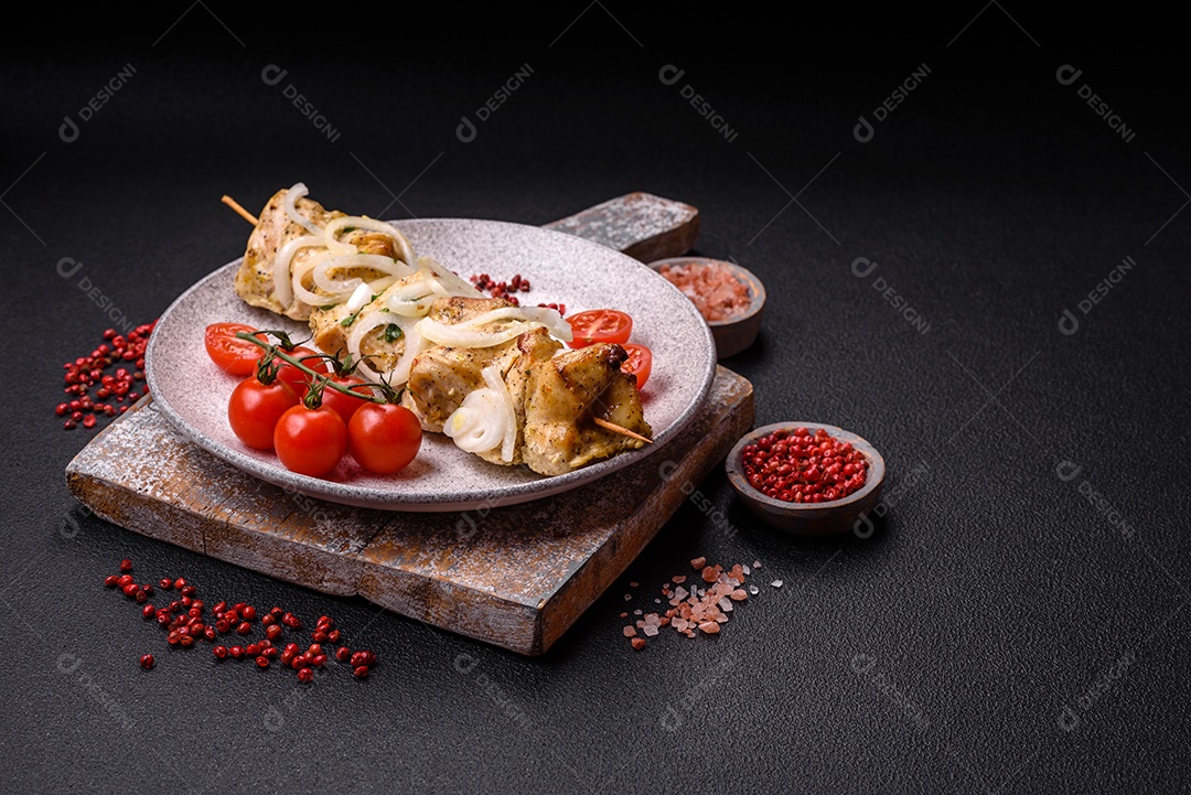 Delicioso kebab de carne de frango fresco com sal, especiarias e ervas sobre um fundo escuro de concreto