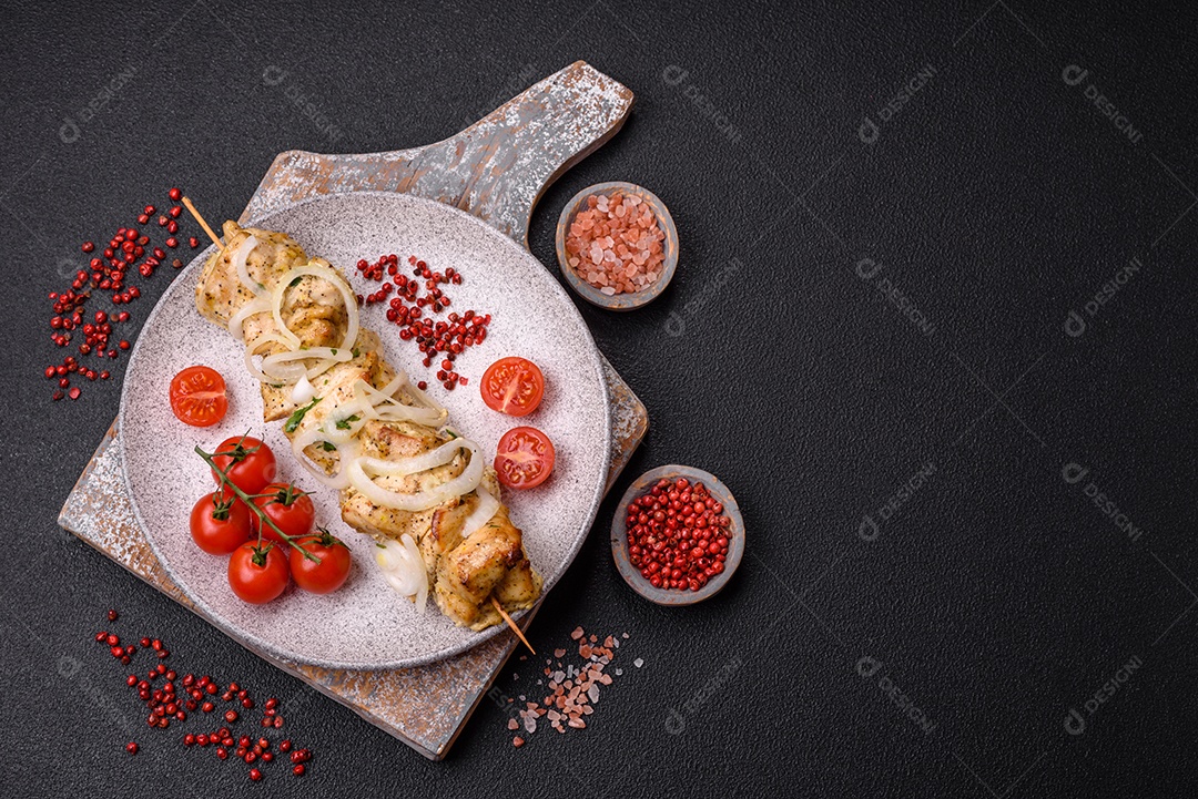 Delicioso kebab de carne de frango fresco com sal, especiarias e ervas sobre um fundo escuro de concreto