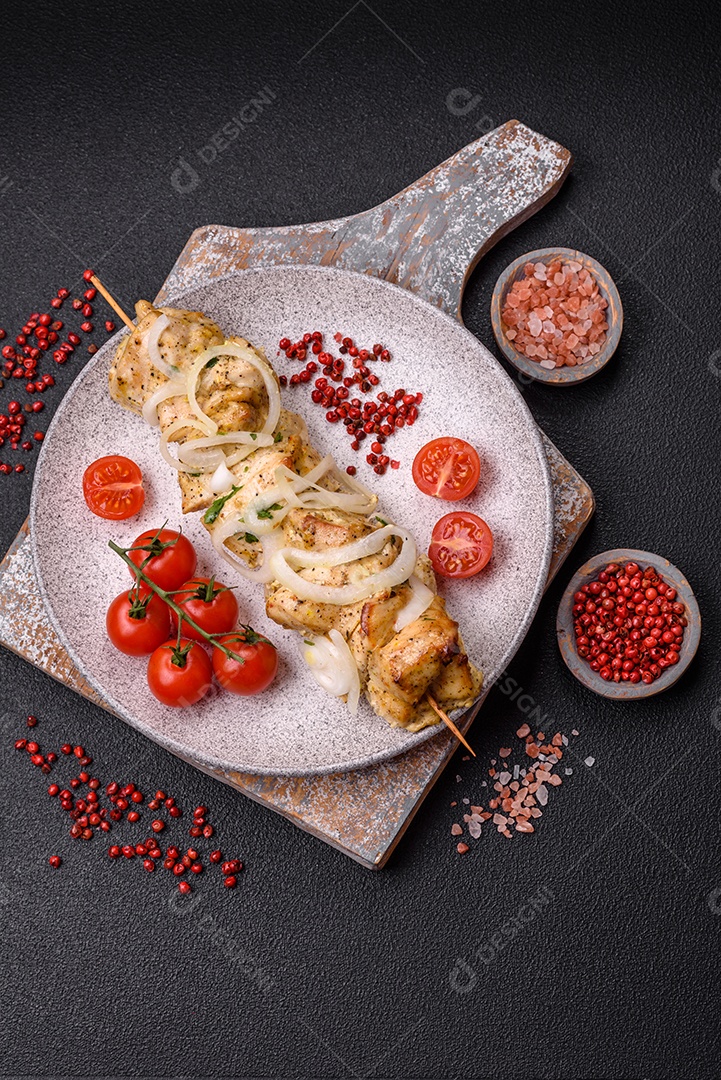 Delicioso kebab de carne de frango fresco com sal, especiarias e ervas sobre um fundo escuro de concreto