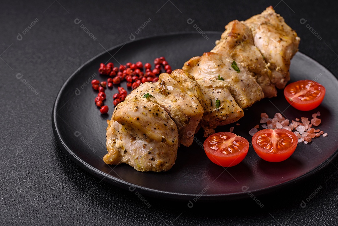 Delicioso kebab de carne de frango fresco com sal, especiarias e ervas sobre um fundo escuro de concreto