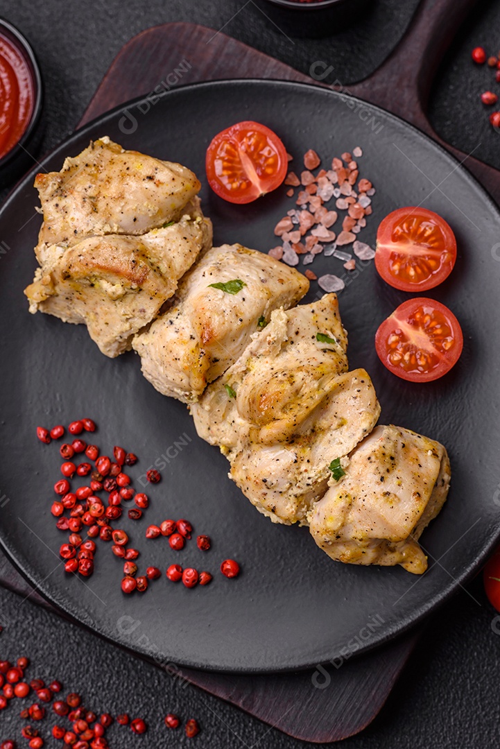 Delicioso kebab de carne de frango fresco com sal, especiarias e ervas sobre um fundo escuro de concreto