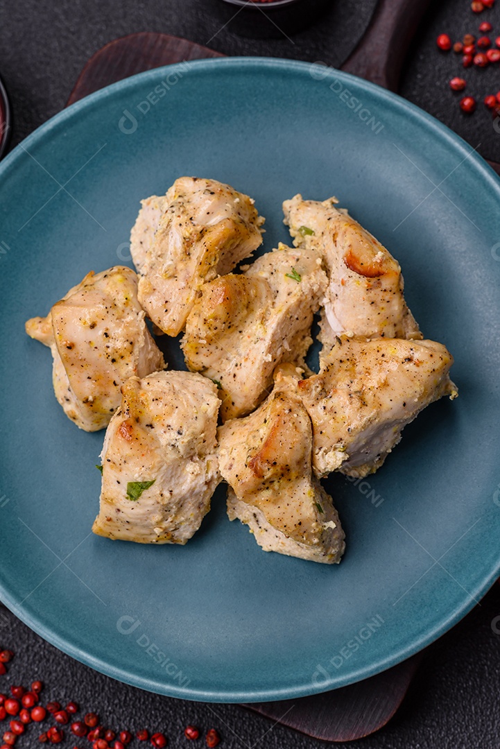 Delicioso kebab de carne de frango fresco com sal, especiarias e ervas sobre um fundo escuro de concreto