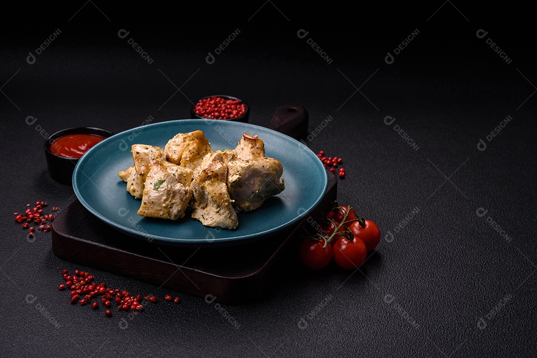 Delicioso kebab de carne de frango fresco com sal, especiarias e ervas sobre um fundo escuro de concreto