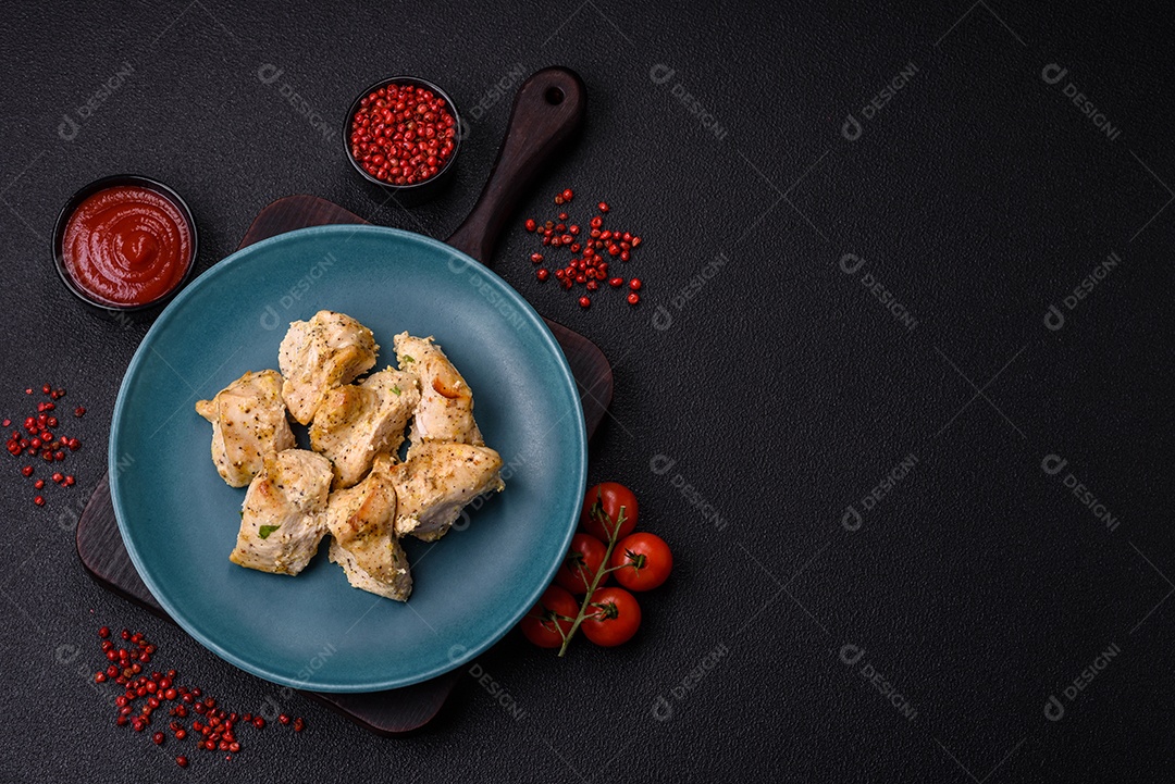 Delicioso kebab de carne de frango fresco com sal, especiarias e ervas sobre um fundo escuro de concreto