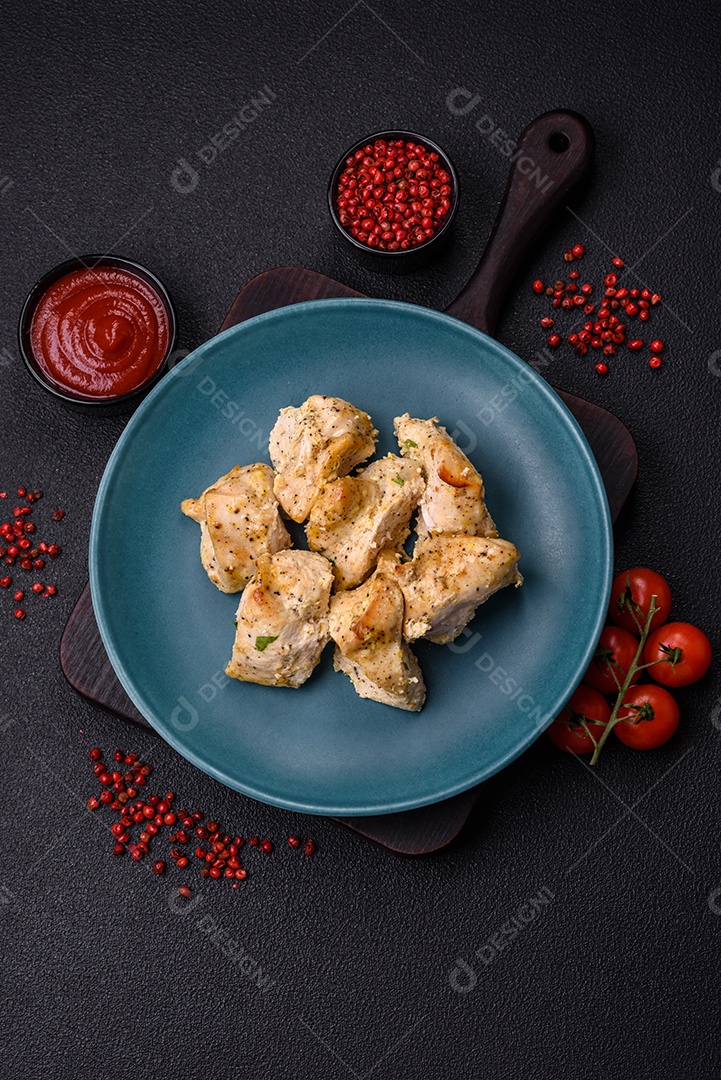 Delicioso kebab de carne de frango fresco com sal, especiarias e ervas sobre um fundo escuro de concreto