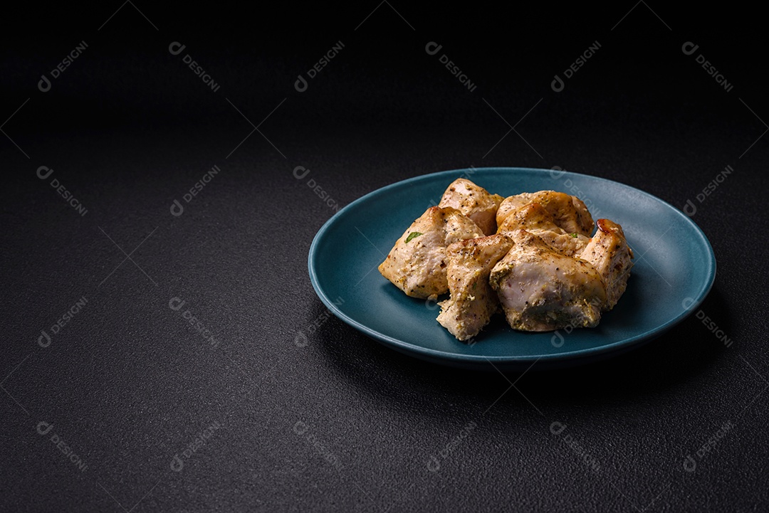 Delicioso kebab de carne de frango fresco com sal, especiarias e ervas sobre um fundo escuro de concreto