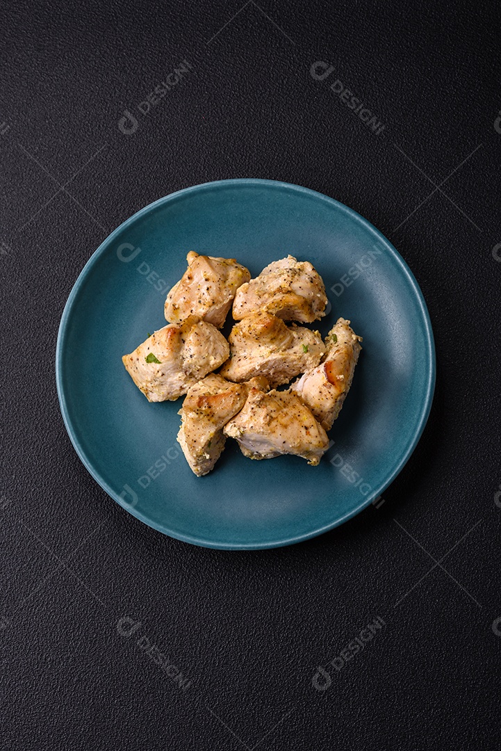 Delicioso kebab de carne de frango fresco com sal, especiarias e ervas sobre um fundo escuro de concreto