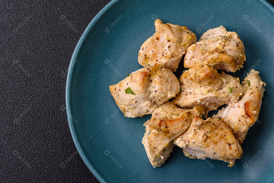 Delicioso kebab de carne de frango fresco com sal, especiarias e ervas sobre um fundo escuro de concreto