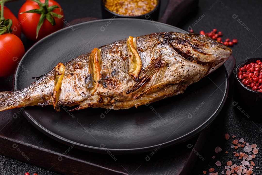 Delicioso dorado assado na grelha com sal, especiarias e ervas sobre um fundo escuro texturizado