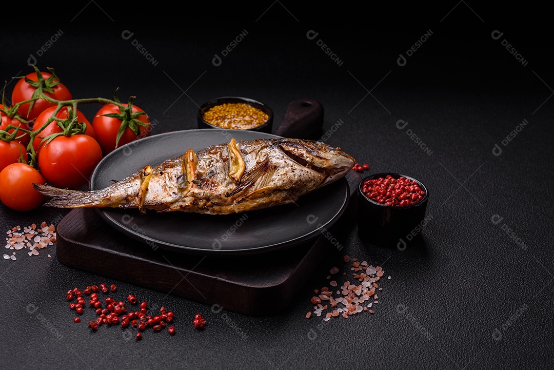Delicioso dorado assado na grelha com sal, especiarias e ervas sobre um fundo escuro texturizado