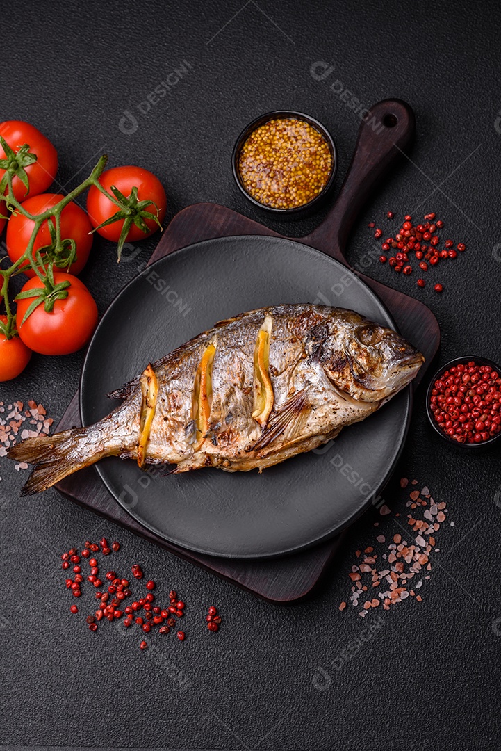 Delicioso dorado assado na grelha com sal, especiarias e ervas sobre um fundo escuro texturizado