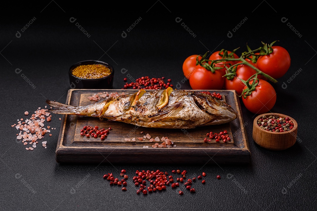 Delicioso dorado assado na grelha com sal, especiarias e ervas sobre um fundo escuro texturizado