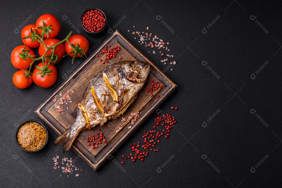 Delicioso dorado assado na grelha com sal, especiarias e ervas sobre um fundo escuro texturizado